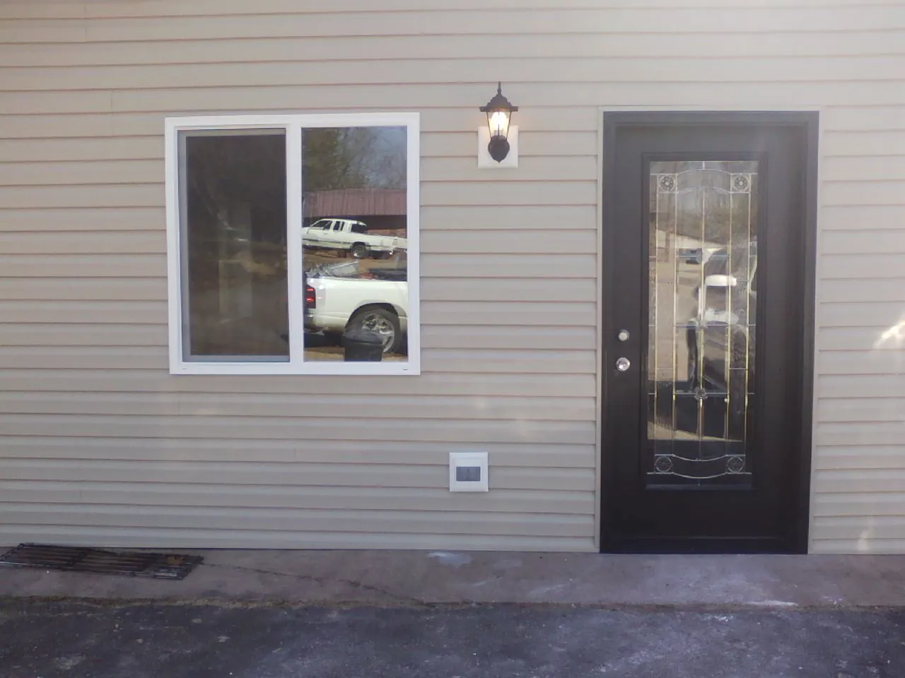 New siding, window and entry door on the side of an addition in Walnut Grove