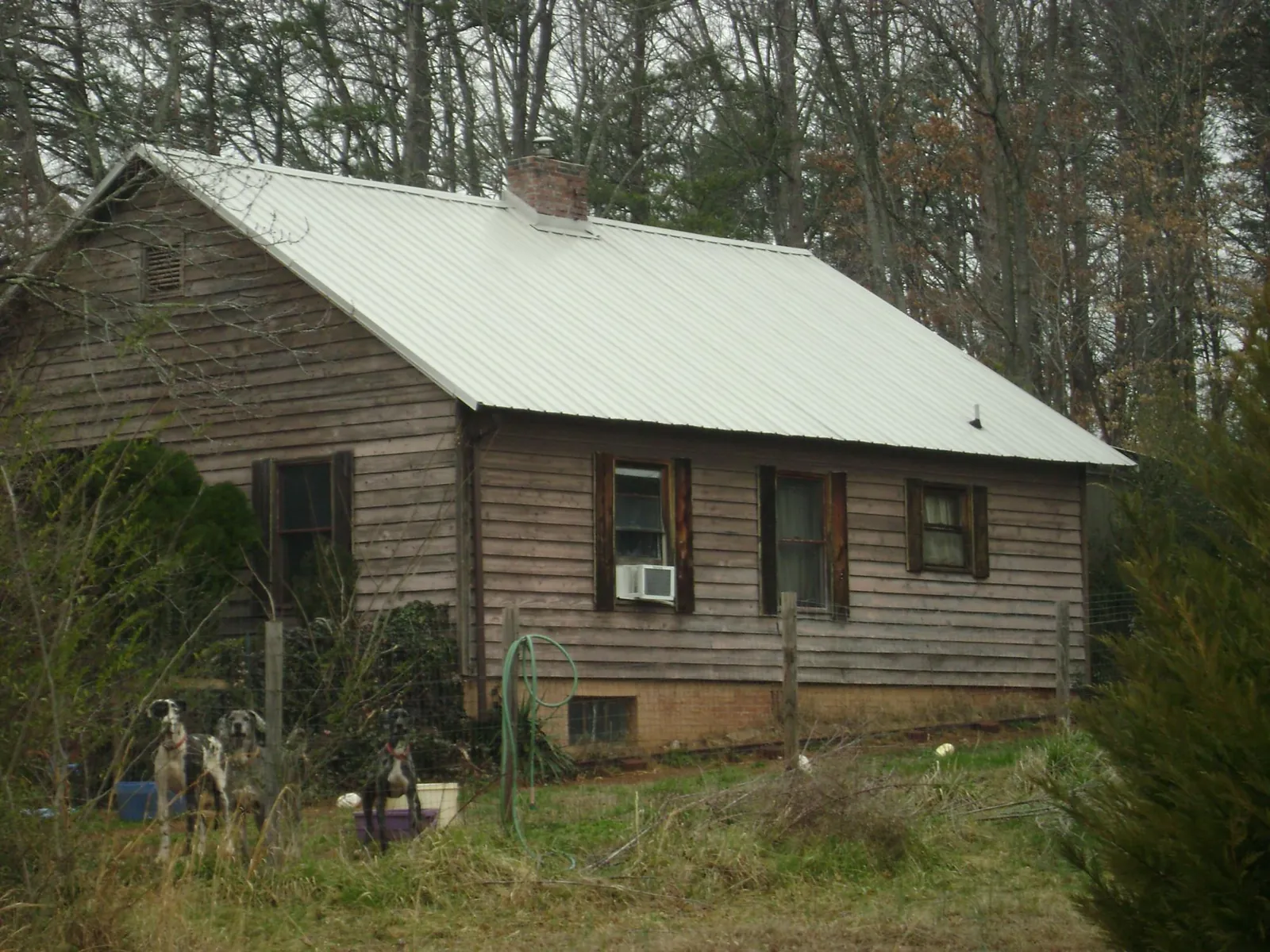 White metal roof on an old wood sided farmhouse, from a Metal Roof Installation job in Walnut Grove